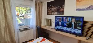 a room with a television on a desk next to a window at 2 Room Flat near Uni Campus Siegen - BR in Siegen +9 photos