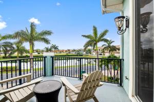 un balcón con 2 sillas y un cubo de basura en 128 Mediterranean Way, en Indian Harbour Beach