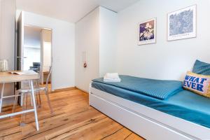 a small bedroom with a bed and a desk at Alpine Lodge 63 in Andermatt