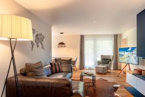 a living room with a brown leather couch and chairs at Alpine Lodge 63 in Andermatt