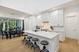una cocina con armarios blancos y una isla de cocina con taburetes en 132 Ocean Estates Dr, en Lakewood Park
