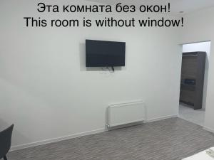 Pokój z telewizorem z płaskim ekranem na ścianie w obiekcie City Centre B&B w Taszkiencie