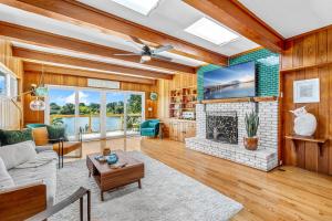 sala de estar con chimenea y ventilador de techo en Mango Shores, en Indian Harbour Beach