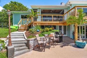 una casa con un patio con mesa y sillas en Mango Shores, en Indian Harbour Beach