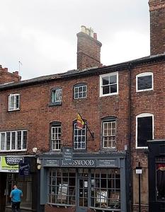 un edificio de ladrillo con un hombre parado frente a él en St Johns Hill Apartments, en Shrewsbury