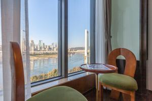 een kamer met een groot raam met uitzicht op de stad bij Aixin Yangtze River International Apartment in Chongqing