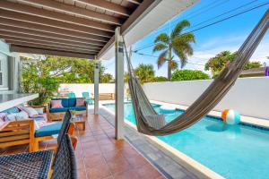 porche con hamaca y piscina en 201 Marion Street, en Indian Harbour Beach
