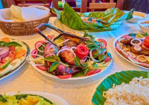 a table topped with plates of food and rice at Cotelac Heritage Lake Resort by VOYE HOMES in Alleppey