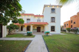 Una gran casa blanca con dos mesas en el patio. en Wecation - 5BR Villa With Private Swimming Pool, en Dubái