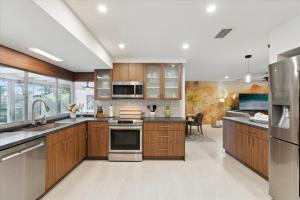Una cocina con gabinetes de madera y electrodomésticos de acero inoxidable. en 307 Brightwaters Dr, en Cocoa Beach