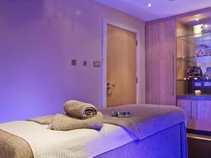 Un dormitorio morado con una cama con una toalla encima. en 2 Bed in St. Mellion 87714, en St Mellion 18 fotos más