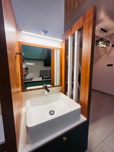a bathroom with a white sink and a mirror at ThunderHill by Casablanca - A Premium Pool Villa in Meenangadi