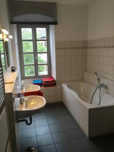 La salle de bains est pourvue d'une baignoire et d'un lavabo. dans l'établissement Kaiserslautern Apartment, à Kaiserslautern