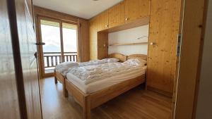 a bedroom with a bed in a room with a window at Plein Ciel VA 031 - MOUNTAIN apartment 8 pers in Veysonnaz