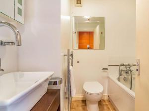 a white bathroom with a toilet and a sink at 2 Bed in Polruan 75740 in Polruan