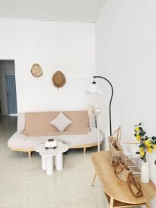 a white room with a bed and a table at Nap House 2- house in center Phan Thiet in Ấp Bình Hưng