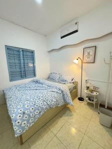 a bedroom with a bed and a lamp and a window at Nap House 2- house in center Phan Thiet in Ấp Bình Hưng