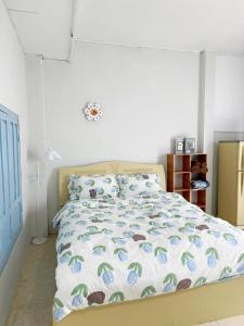 a bedroom with a bed with a comforter and pillows at Nap House 2- house in center Phan Thiet in Ấp Bình Hưng +7 photos