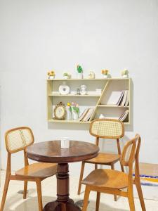 a table and chairs in a room with a shelf at Nap House 2- house in center Phan Thiet in Ấp Bình Hưng