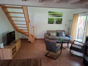 ノルトホルンにあるFerienhaus Nordhorn - Auf Wolke 7 und Seeparadiesのソファとテーブルのあるリビングルーム