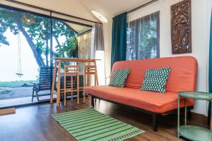 a living room with an orange couch and a table at Beach front cottage in Haad Pleayleam +10 photos