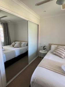 a bedroom with two beds and a mirror at Double room with shared bathoom in Auburn