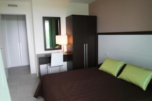 a bedroom with a bed and a desk and a mirror at Residence Ormeggio in Grado