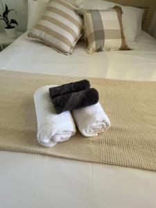 two towels sitting on top of a bed at Double room with shared bathoom in Auburn +5 photos