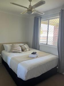 a bedroom with a large bed with a ceiling fan at Double room with shared bathoom in Auburn