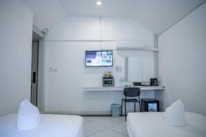 a white room with two beds and a chair at DownTown Hotel in Luang Prabang