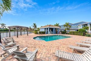 Un patio con sillas y una piscina. en 148 Mediterranean Way, en Indian Harbour Beach