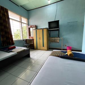 a living room with two beds and a tv at Hotel Budi Famili Budget Syariah in Ciamis