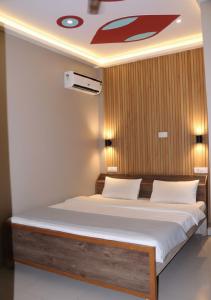 a bedroom with a bed with a wooden wall at Hotel ShivDham in Naimishāranya