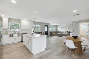 cocina y sala de estar con armarios blancos y mesa en 520 Escambia St, en Indian Harbour Beach
