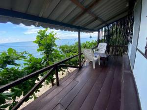 a porch with two chairs and the ocean in the background at maylamean bungalow kohchang in Ban Khlong Son
