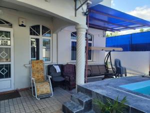 a patio with chairs and a swimming pool at Blue Horizon Villa in Grand Baie in Grand-Baie