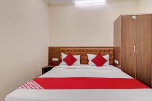 a bedroom with a large bed with red pillows at Super Collection O Ashraya Paradise in Bengaluru +27 photos
