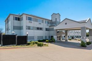 a large white building with a fence in front of it at Super 8 by Wyndham Weatherford in Weatherford