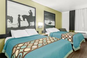 a hotel room with two beds and a painting on the wall at Super 8 by Wyndham Weatherford in Weatherford