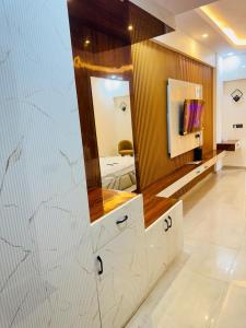 Un baño con un gran espejo y un lavabo. en Omaxe Hazratganj Studios, en Lucknow
