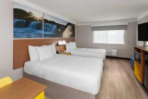 アーリントンハイツにあるDays Inn & Suites by Wyndham Arlington Heightsの大きなベッドとテレビがあるホテルの部屋 +67枚の写真