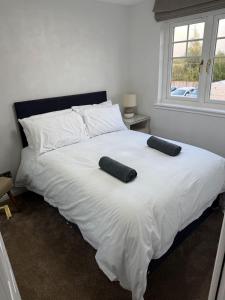 Una cama blanca con dos almohadas negras. en Luxury townhouse in Stirling, en Stirling