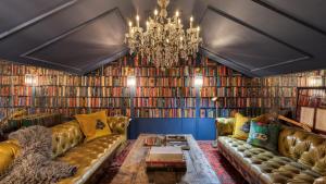 a living room with a couch and a chandelier at Iconic 6BR Desert Retreat w Pool Pickleball Fire Pit Joshua Tree Masion by AvantStay in Joshua Tree