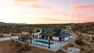 uma vista aérea de uma casa com piscina em Iconic 6BR Desert Retreat w Pool Pickleball Fire Pit Joshua Tree Mansion by AvantStay em Joshua Tree