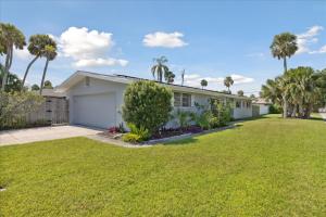 una casa blanca con palmeras y un patio en 4880 N Banana River Sandys Place, en Cocoa Beach