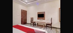 BidadiにあるHotel O Bidadi Railway Junction Bangalore Formerly Ejallaのベッドとテーブルと椅子のあるホテルの部屋