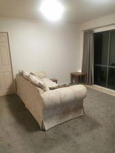 a living room with a couch and a window at Double Room Free WIFI in Hamilton