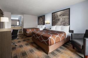 a hotel room with two beds and a flat screen tv at Super 8 by Wyndham Covington in Covington +26 photos