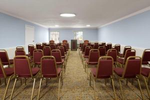 an empty room with red chairs and blue walls at Super 8 by Wyndham Covington in Covington