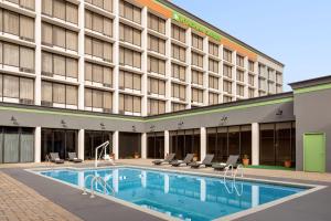 a hotel with a swimming pool in front of a building at Wyndham Garden Atlanta Airport in Atlanta